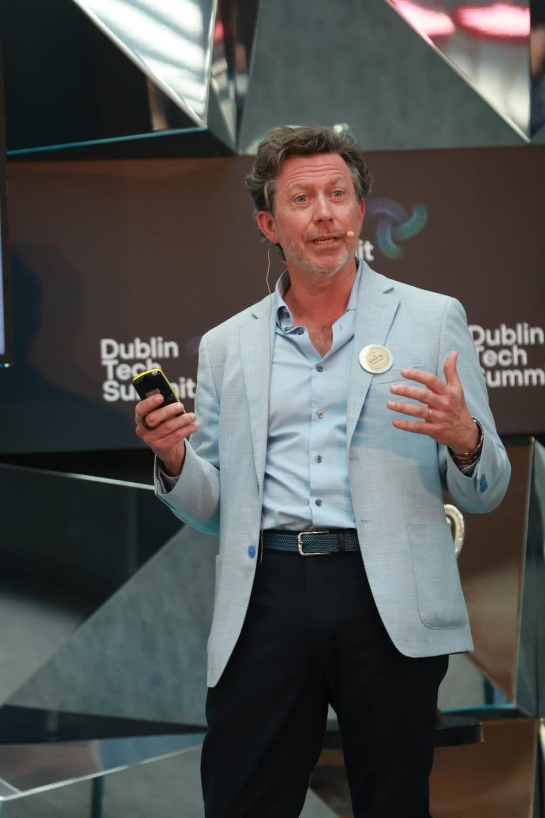 Man in a light blue blazer gestures while speaking at the Dublin Tech Summit.